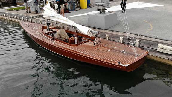 Traditionsreicher Meisterbetrieb Holzboot im Wasser neben Kran